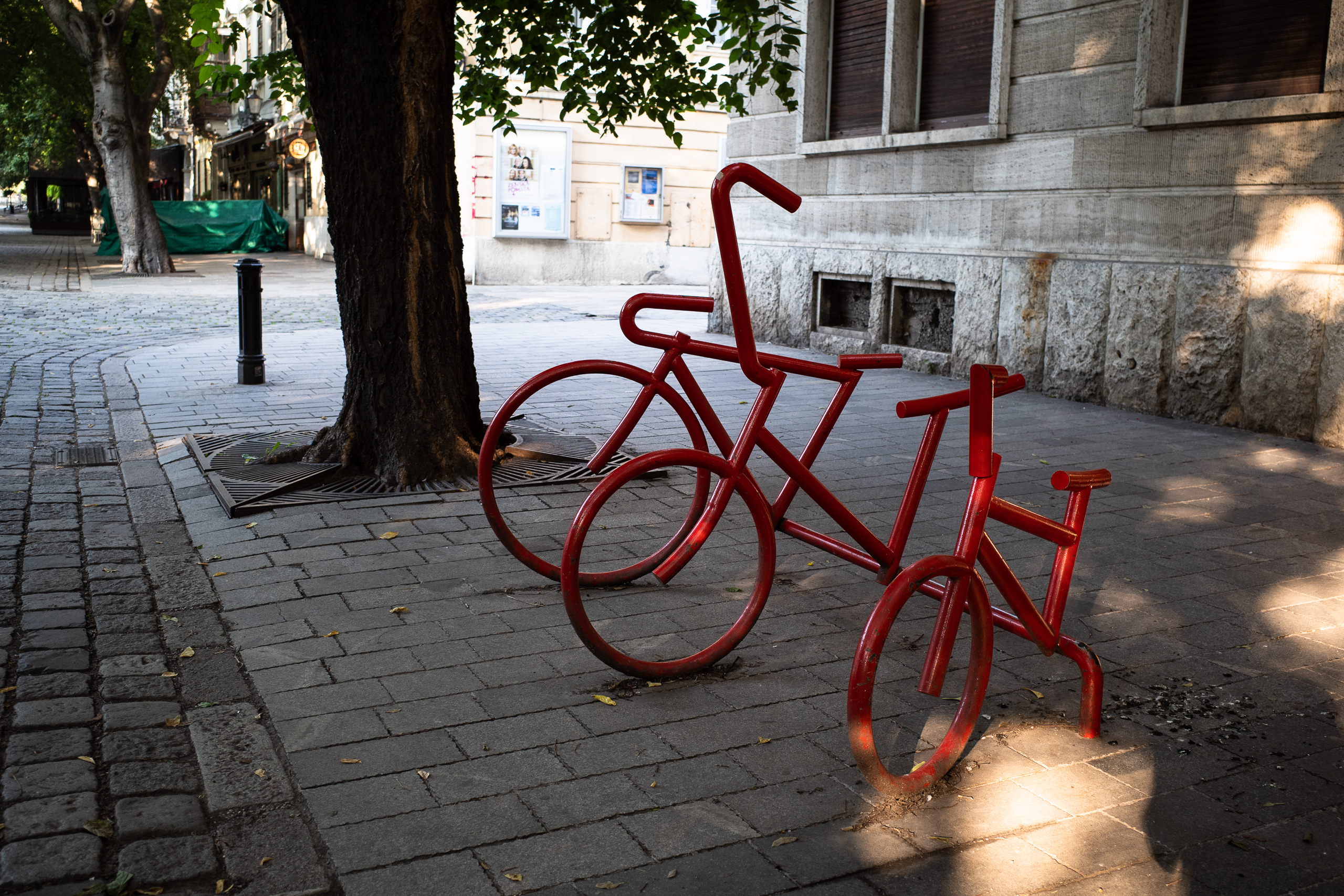 Ein rotes Riesenfahrrad als Fahrradständer am Gehsteig